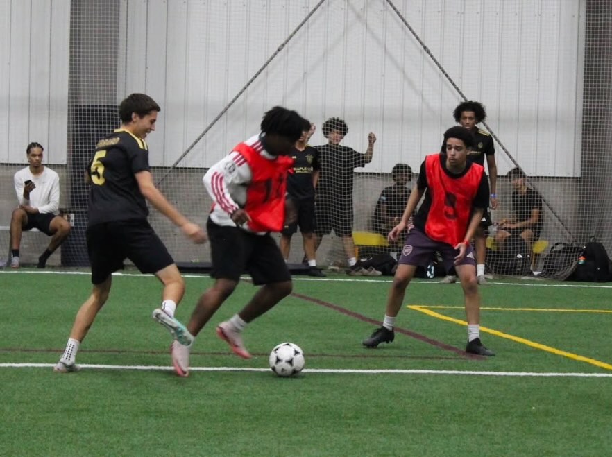 Two teams closing in on the ball in the middle of a match